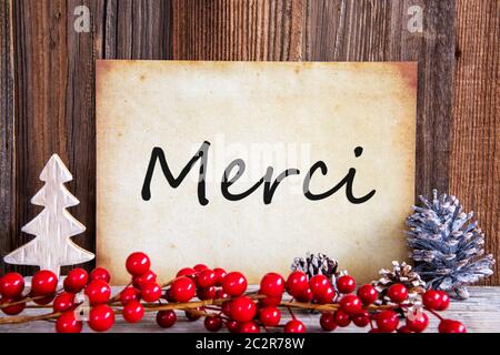 Carta con testo francese mezzi Merci Grazie. Decorazione di natale e lo sfondo di legno Foto Stock