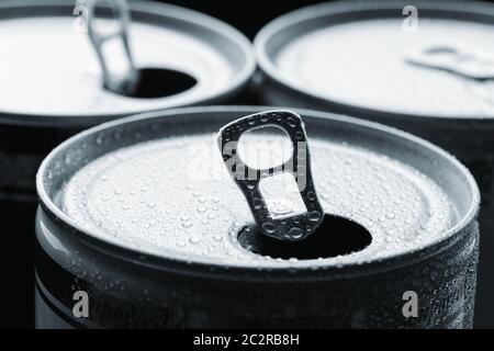 Tre lattine in alluminio isolato su nero Foto Stock