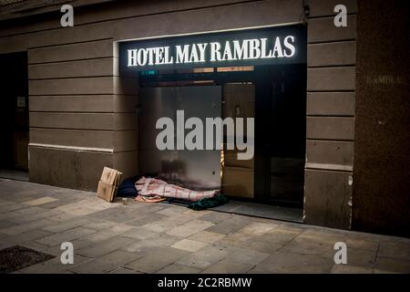 18 giugno 2020, Barcellona, Catalogna, Spagna: Un uomo senza dimora dorme alla porta di un albergo chiuso vicino a Las Ramblas a Barcellona, la Spagna solleverà i controlli alle frontiere con gli stati dell'area Schengen a partire dal 21 giugno. Barcellona entra oggi nella fase 3 di misure di blocco che agevolano la limitazione della mobilità tra le regioni della Catalogna. Credit: Jordi Boixareu/Alamy Live News Foto Stock