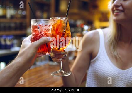 Donna e uomo che alzano un bicchiere di coda di cocco Foto Stock