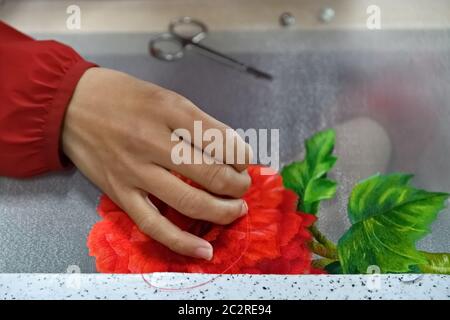 Mano ricamata con ago e filo di seta su tela con fiori esotici primo piano Foto Stock