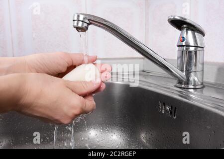 Donna le lava le mani con sapone Foto Stock