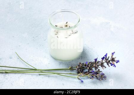 Una candela profumata di lavanda con fiori di lavanda e un luogo per il testo. Zero Waste Natale concetto, un regalo fatto a mano di Capodanno in Foto Stock