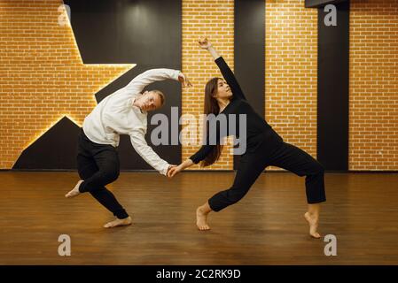 Partner di danza contemporanea, coppia in posa in studio. Ballerini maschili e femminili in allenamento in classe, danza moderna, stretching esercizio Foto Stock