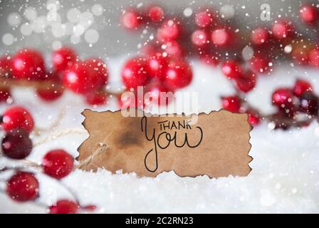 Etichetta bruciato con la calligrafia inglese Grazie. Red decorazione di Natale con la neve e i fiocchi di neve Foto Stock