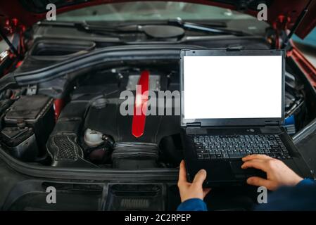 Ingegnere calcolatore rende la diagnostica della vettura in auto-servizio. Cablaggio del veicolo ispezione Foto Stock