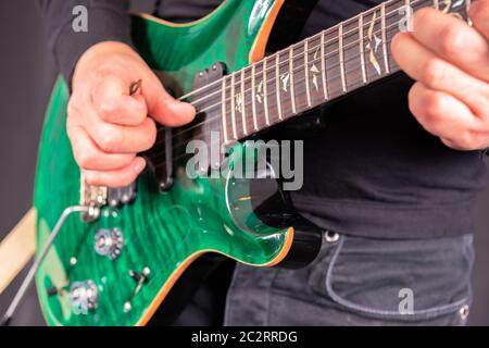 Le mani dell'uomo suonano la chitarra elettrica Foto Stock