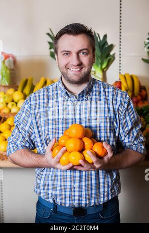 Ritratto di sorridente tiene in mano i tangerini maturi. Foto Stock