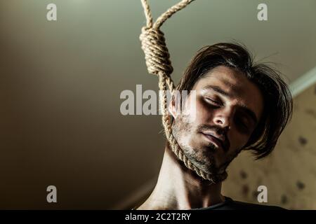 Concetto di suicidio, uomo depresso con un cappio intorno al collo. Foto Stock