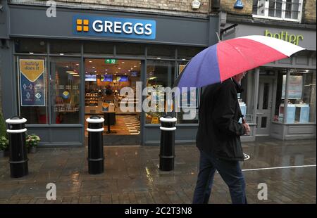 Una persona cammina oltre un ramo di Greggs a Winchester, Hampshire, mentre la catena di panetteria riapre 800 negozi in tutto il Regno Unito a seguito dell'allentamento delle restrizioni di blocco di coronavirus. Foto Stock