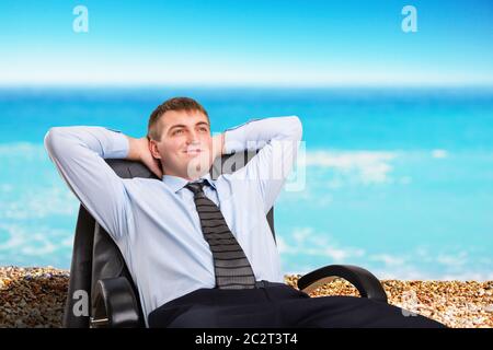 Happy businessman sognare vacanza seduto in una sedia Foto Stock