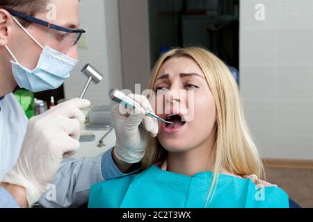 Ritratto di giovane donna che vede un dentista, la donna sta sperimentando dolore Foto Stock