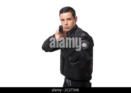 Agente di polizia armato mira con una pistola, nero uniforme con una blindatura corporea, sfondo bianco, vista frontale. Poliziotto in munizioni speciali Foto Stock