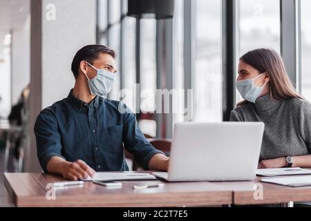 primo piano. i colleghi di lavoro parlano seduti al tavolo dell'ufficio. Foto Stock