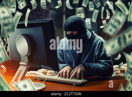 Hacker in maschera rubando informazioni e denaro in ufficio Foto Stock