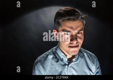 Giovane uomo d'affari spooky nella stanza buia Foto Stock