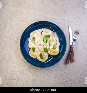 funghi agnolotti su piatto blu. Piatto tradizionale di cucina italiana Foto Stock