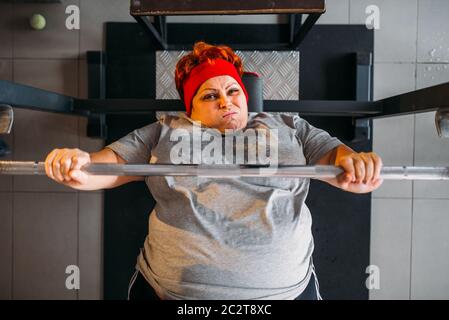 Grasso donna sudate, allenamento con barbell in palestra, vista dall'alto. Calorie bruciare, femmina obesi in persona lo sport club Foto Stock