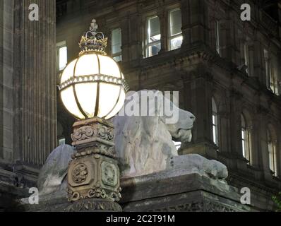 la vecchia luce di strada e la scultura dei leoni nel palazzo del municipio di leeds del 19° secolo di notte con la storica biblioteca Foto Stock