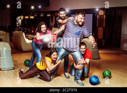 Amici divertirsi giocando a bowling Foto Stock