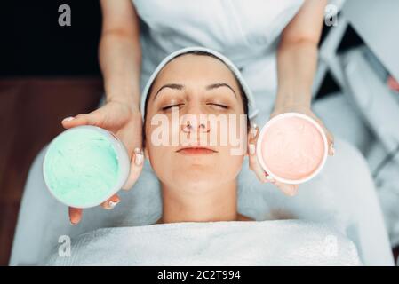 Estetista mani con crema contro la faccia del paziente Ringiovanimento cosmetica, cosmetologia clinica. Cura della pelle del viso in spa salone, la cura della salute Foto Stock