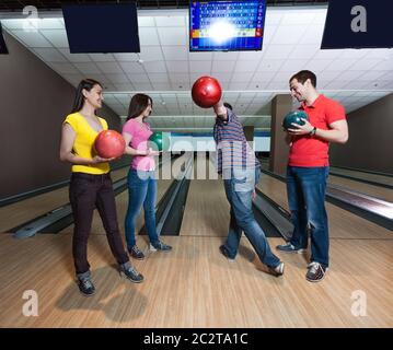 Amici divertirsi giocando a bowling Foto Stock