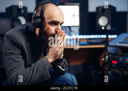 Produttore del suono ascolta composizione in studio di registrazione. Professional audio di musica e tecnologia di miscelazione Foto Stock