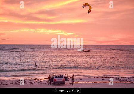 Parasailing come il sole tramonta sulla città costiera di pescatori di Cervantes, Australia occidentale Foto Stock