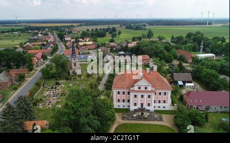 12 giugno 2020, Brandeburgo, Groß Rietz: Il castello Groß di Rietz con la chiesa del villaggio e il cimitero (vista aerea con un drone). "Non sono il signore del castello, ma l'arte", dice Percy Bongers. Il suo amore per il castello barocco Groß Rietz (Oder-Sprea) iniziò dieci anni fa, quando la casa padronale, che fu costruita intorno al 1700 ed è un edificio storico, era ancora un grande cantiere. La Brandenburgische Schlösser GmbH aveva preso il controllo della proprietà con la sua façade rosa e bianca dal comune a metà degli anni '90 per salvarla da ulteriore decadimento. Più di cinque milioni di euro sono stati versati al restor Foto Stock