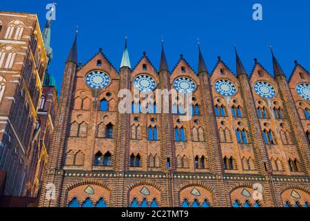 Stralsund, Germania. 15 giugno 2020. Vista della chiesa di San Nikolai e del municipio (r) all'ora blu. I dischi di gioielleria parzialmente placcati in oro, circa 80 kg, sono stati realizzati intorno al 1880 secondo il modello tardo medievale. Si presume che i dischi delle stelle simboleggino il regno dei cieli, che come ordine divino si trova sopra l'ordine terreno, umano - il municipio con il suo consiglio. Il municipio di Stralsund, patrimonio dell'umanità, è uno dei più importanti edifici secolari anseatici della regione del Mar Baltico. Credit: Stefan Sauer/dpa-Zentralbild/dpa/Alamy Live News Foto Stock