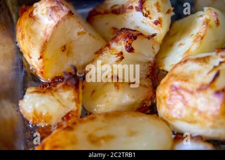 Patate arrosto appena cotte, pronte per essere versate in un recipiente da portata Foto Stock