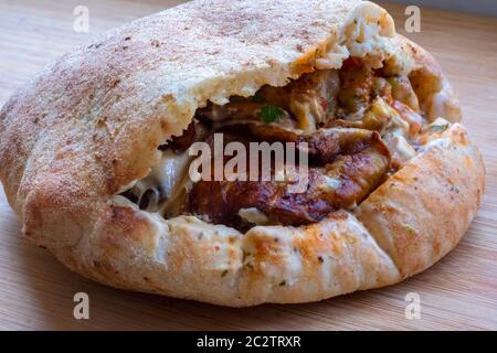 Sandwich Sabich o sabih servito in pita farcito con melanzane fritte, uova sode, insalata, prezzemolo e salsa tahini. Sabich si basa su un piatto ebraico iracheno tradizionale preparato per Shabbat che è stato portato in Israele dagli ebrei iracheni che si sono trasferiti negli anni quaranta e cinquanta. Foto Stock