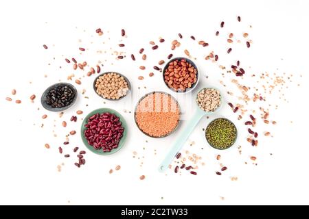 Legumi, top shot su uno sfondo bianco. Gli impulsi di vivaci tra cui colorato fagioli, lenticchie, ceci, un piano di composizione di laici Foto Stock