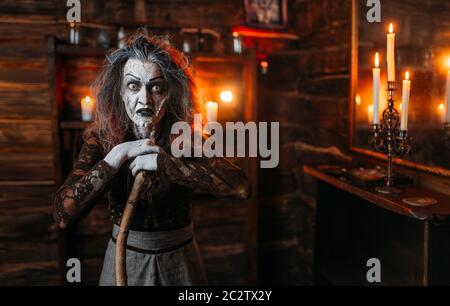 Scary strega con una canna a specchio e candele, poteri oscuri di stregoneria, seance spirituale. Femmina chiamate foreteller gli spiriti Foto Stock