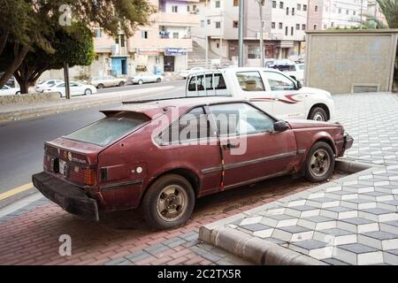 Abha / Arabia Saudita - 23 gennaio 2020: Auto rossa vecchia e arrugginita parcheggiata sulla strada Foto Stock