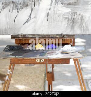 Antica tavolozza di arte in legno e una tela pronta per la pittura posta su un cavalletto Foto Stock