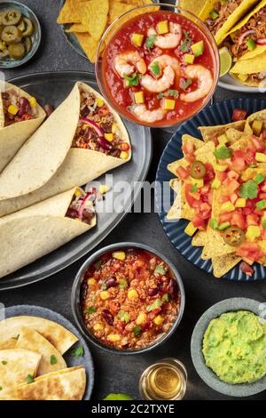 Cibo messicano, molti piatti della cucina del Messico, piatti, top-down su sfondo nero. Cocktail di gamberi, nachos, guaca Foto Stock