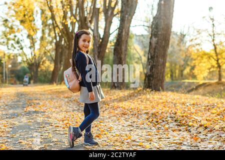 Ragazza carina con zaino andando a scuola Foto Stock