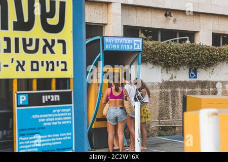 Tel Aviv/Israel-13/10/18: Le giovani donne pagano il parcheggio, utilizzando il macchinetta per biglietti in un parcheggio a Tel Aviv. Un distributore automatico di biglietti è un Foto Stock