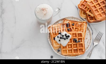 Colazione con waffle belgi e cappuccino. Spazio di copia