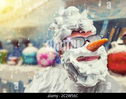 Strano uomo sorridente con il naso di carota e con schiuma da barba sul suo volto Foto Stock