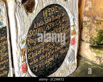 Una pietra miliare all'ingresso della chiesa di Santa Maria a Henbury, Bristol, dove la tomba di un uomo africano schiavizzato è stata vandalizzata in un apparente 'attacco di rappresaglia' a seguito della caduta di una statua del commerciante di schiavi Edward Colston a Bristol. Due lapidi del monumento a Scipio Africanus, patrimonio dell'umanità di grado II, sono state abbattuti e un messaggio è stato scagliato in gesso su pietre vicino. Foto Stock