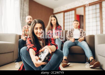 Happy amici con joystick riproduce video console a casa. Un gruppo di giocatori che giocano videogioco, i giocatori hanno un concorso Foto Stock