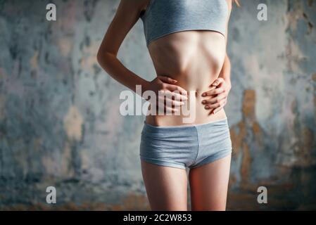 Persona di sesso femminile con cintura slim, perdita di peso e anoressia. Grassi o calorie burning concetto, la malattia Foto Stock