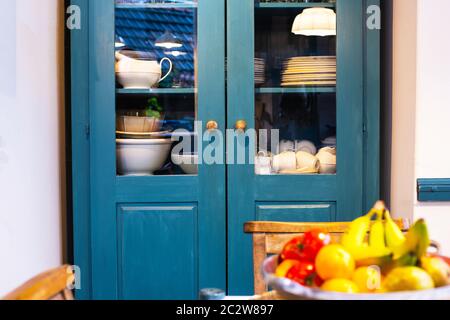 Diversi piatti bianchi in armadio in cucina vintage design con blu colori retro Foto Stock