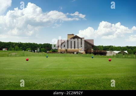 Quattro sfere di colore sul campo da golf, trampolino di lancio, nessuno. Prato verde in sport club, rifilando un prato per gioco, parco giochi vuota Foto Stock