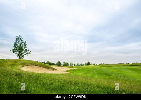 Rifilato il prato e bunker di sabbia per giocare a golf sul campo da golf, nessuno. Prato in sport club, parco giochi con erba verde Foto Stock