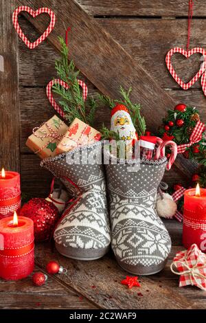 Stivali in maglia con piccoli regali e caramelle per Natale Foto Stock