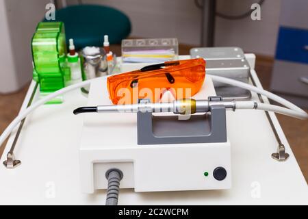 Dispositivi dentali, strumenti e maschera protettiva sul tavolo Foto Stock