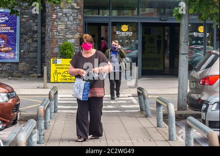 Bandon, West Cork, Irlanda. 18 Giugno 2020. Una donna indossa una maschera facciale nel parcheggio del Riverview Shopping Centre, Bandon, per proteggersi dal Covid-19. Credit: Notizie dal vivo di AG/Alamy Foto Stock